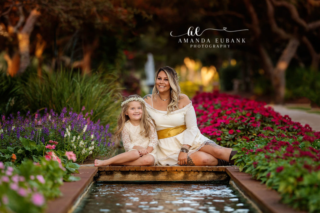 Watercolor family portrait — horizontal mom-and-daughter garden lawn portrait; photographed by Amanda Eubank Photography along Florida’s Emerald Coast.