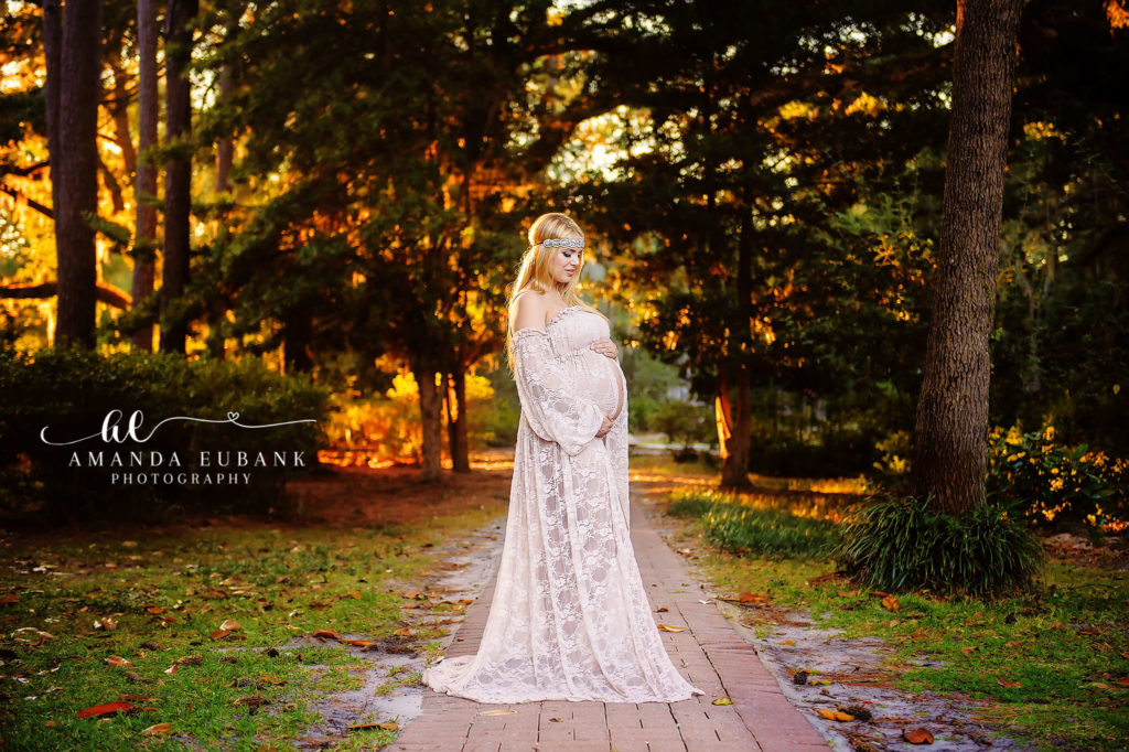 Pregnant blonde mother in cream lace boho gown with beaded headband on autumn boardwalk