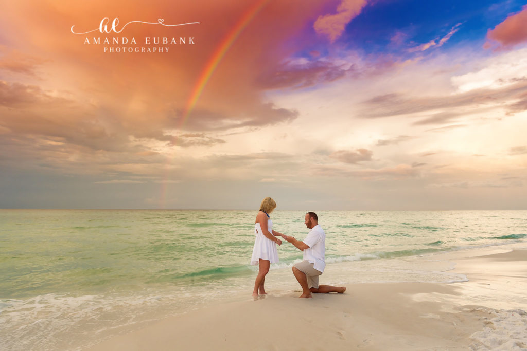 30A surprise marriage proposal engagement photography at sunrise with a rainbow arching over the Gulf.