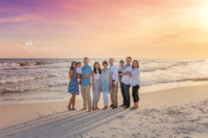 Extended family on Watercolor Florida beach in coordinated chambray and white at sunset — pastel sky family smile