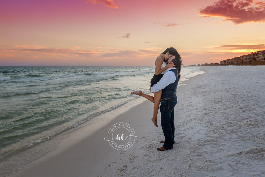 Jessica and Kyle in a tender embrace silhouetted against the sun-streaked horizon under lavender Destin twilight.
