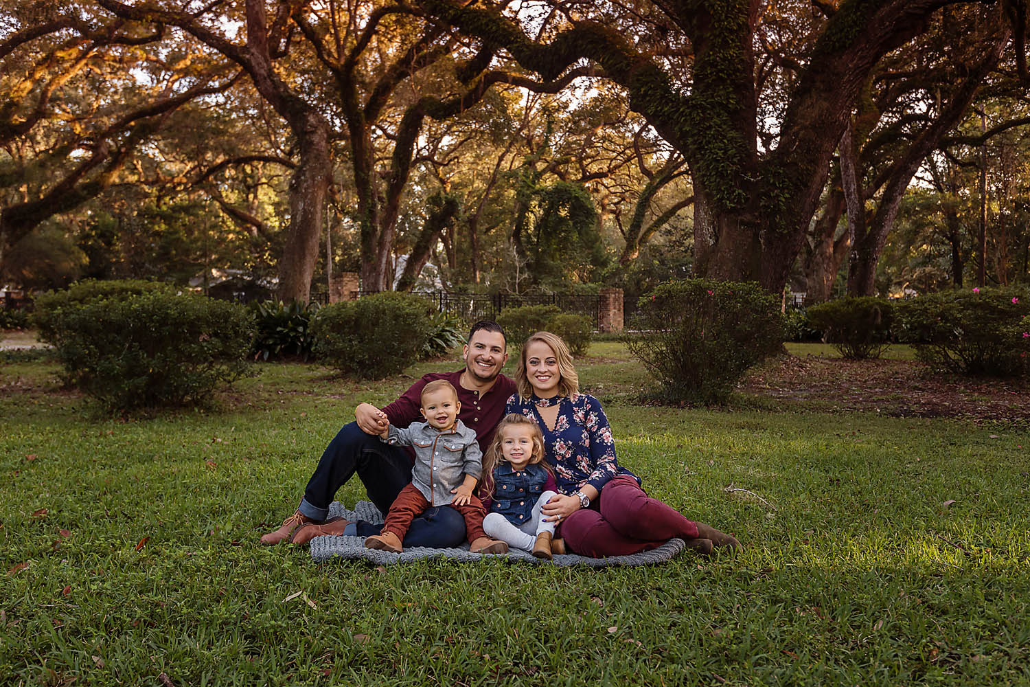 Eden Garden Photographer 013 Prieto family of four seated close together on a blanket at Eden Gardens