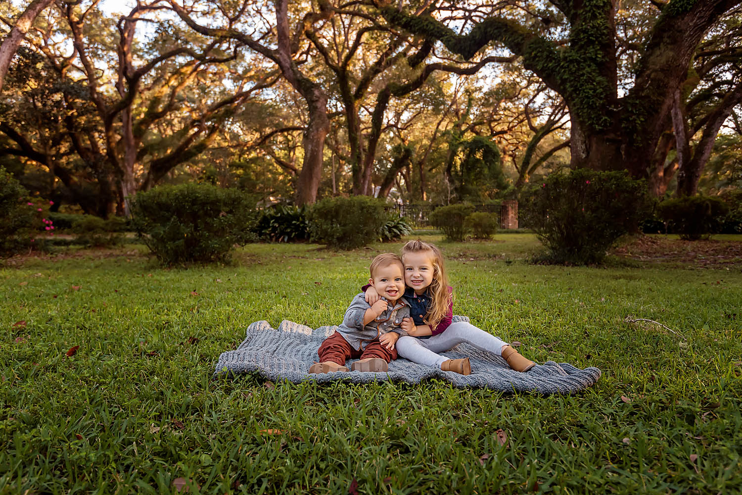 Eden Garden Photographer 014 Two Prieto siblings sitting together on a blanket beneath the Eden Gardens oaks