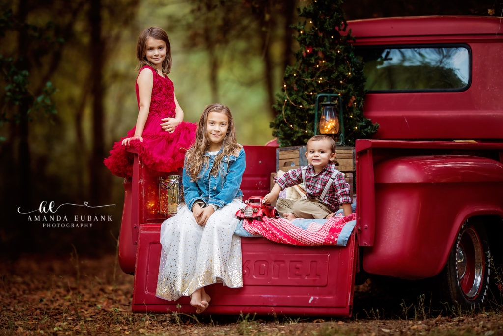 the seven mini-session kids gathered at the campfire and Coca-Cola crates at a Texas red truck and campfire mini-session photographed by Amanda Eubank Photography in soft autumn-evening glow.