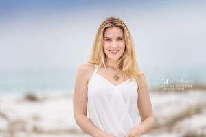 Luminous editorial brand portrait of a model in a soft pastel gown final portrait against a sun-bleached gulf horizon captured under creamy diffused sunshine
