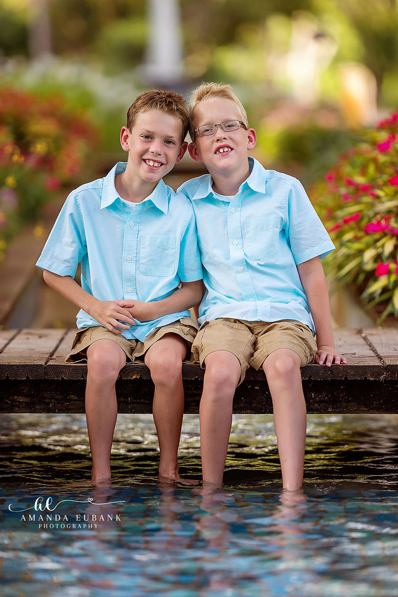 30A Florida family photographer captures two brothers in matching blue shirts by reflecting pool