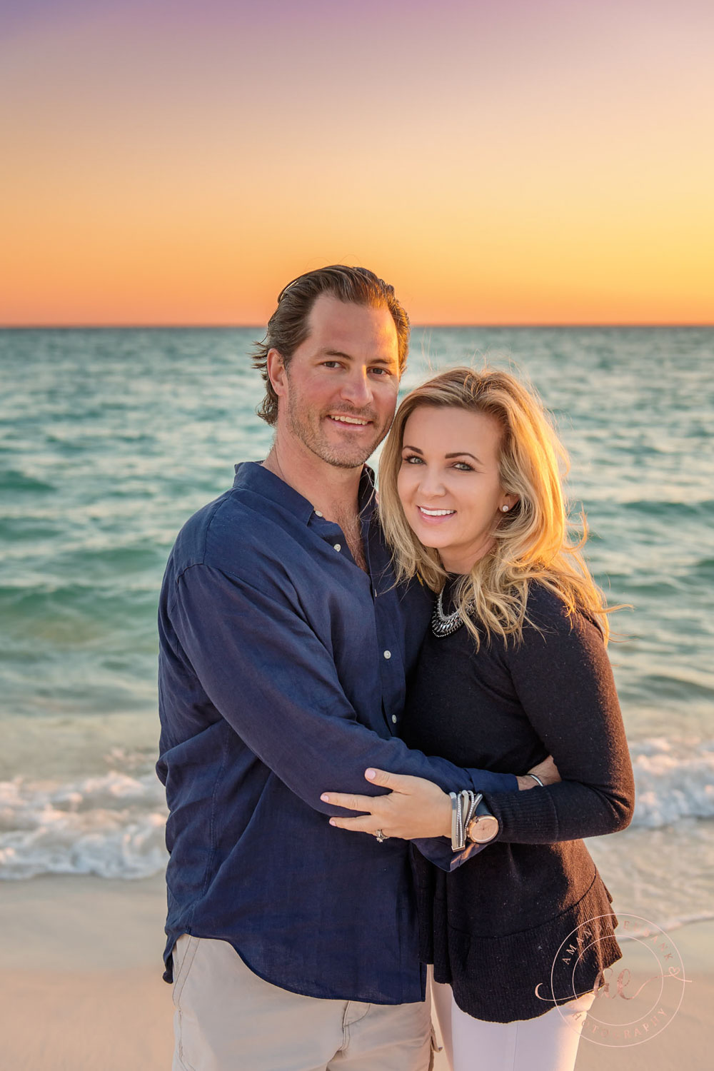 CARILLON BEACH FLORIDA ENGAGEMENT PHOTOGRAPHER Carillon Beach Florida engagement photographer captures couple in navy and white embracing on beach at peach sunset