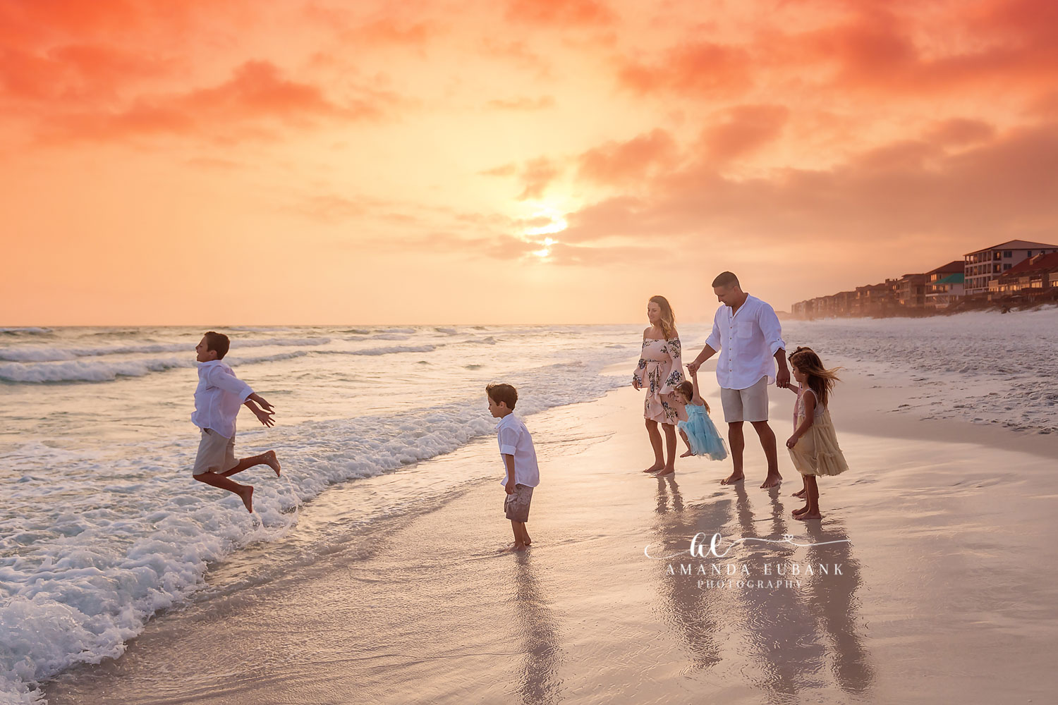 Inlet Beach Florida Family Photographer — Family of Five Playing in the Surf at Sunset Family of five with parents standing as their kids play in the surf at a glowing orange sunset on Inlet Beach, Florida.