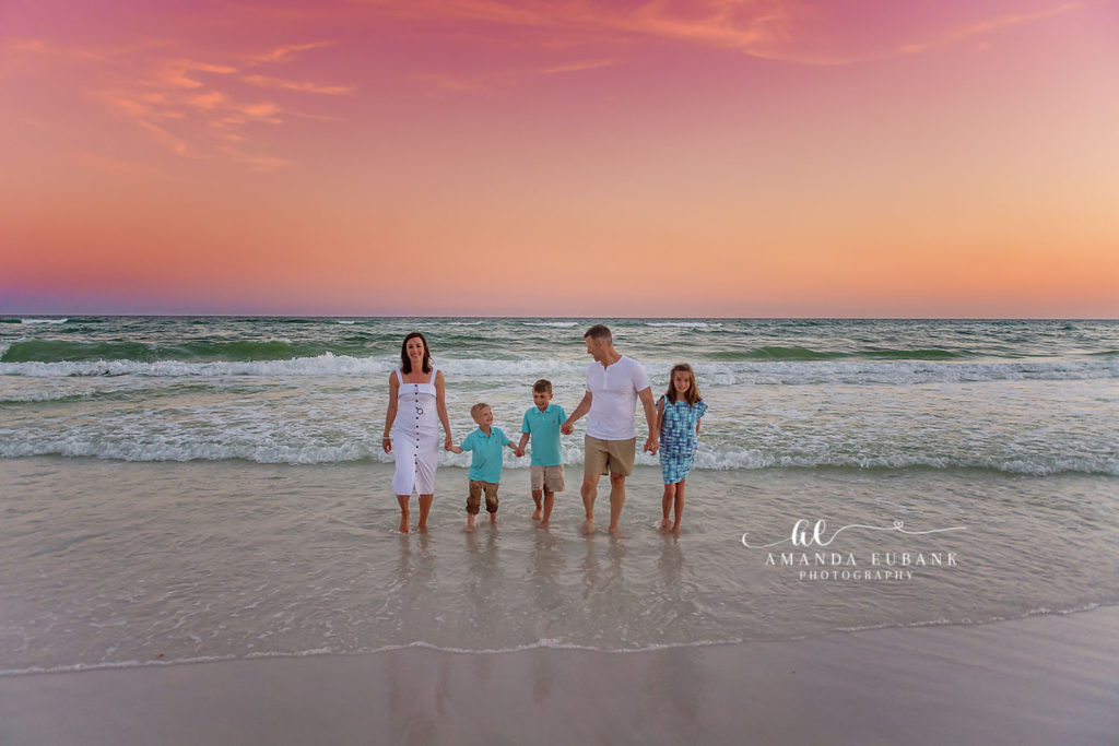 Henderson family walking hand in hand as the sun sets behind them