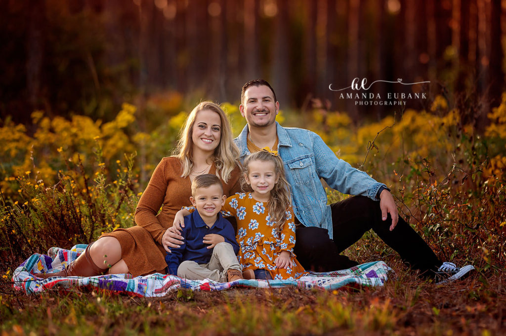 Mom kneeling beside her children in the yellow wildflowers