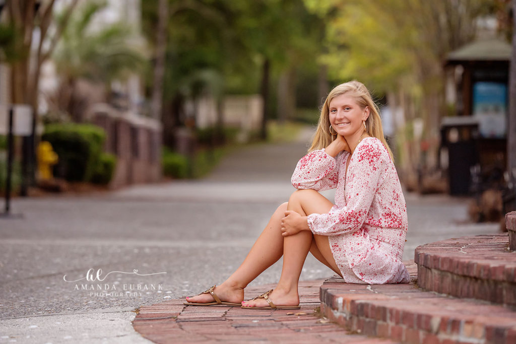 Senior girl multi-look session including brick courtyard and sunset surf silhouette at Rosemary Beach senior portrait locations with sherbet horizon.