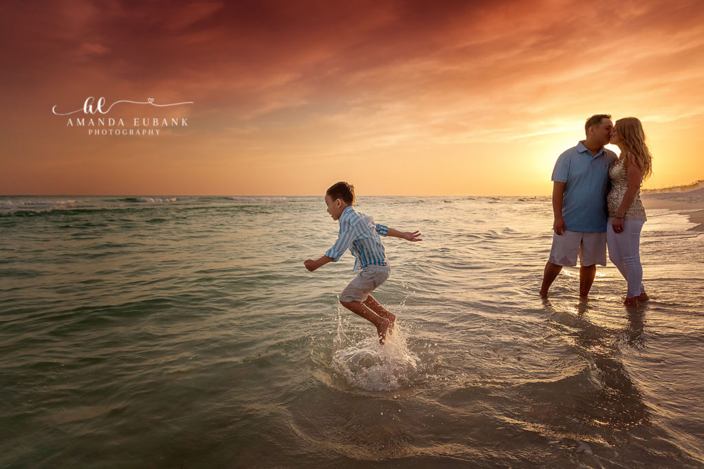 Joyful environmental frame of the family on the sand in painted dusk