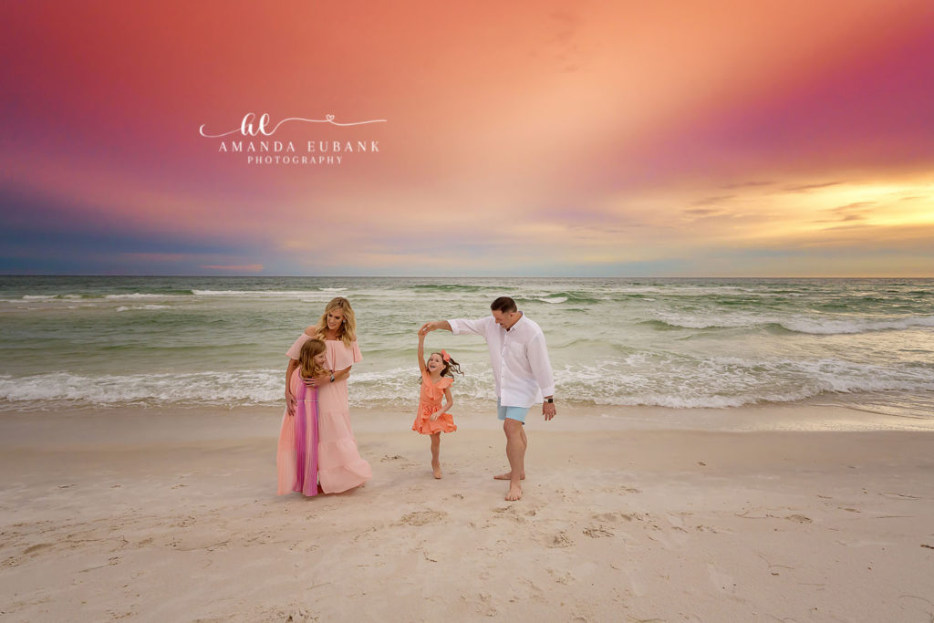 Soft-hearted mom-and-daughters moment on the shoreline in sherbet glow