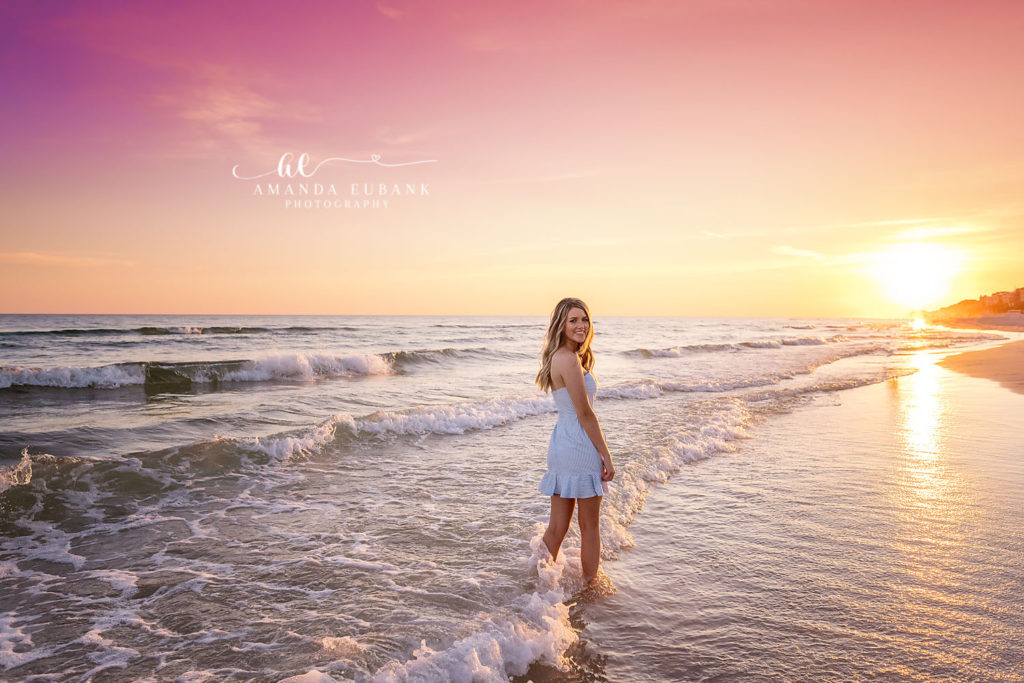 Ella gazes toward the gulf in flowing blue and white during her Rosemary Beach senior session