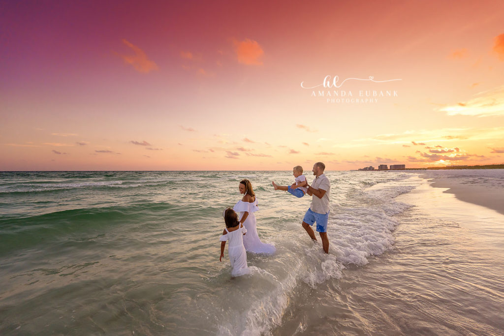 Family gathers close in coordinated whites at the Henderson Beach Resort gulf shoreline