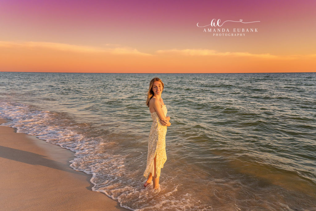 Sunset Rosemary Beach senior portrait of Kaitlyn in a soft white lace dress on the shoreline