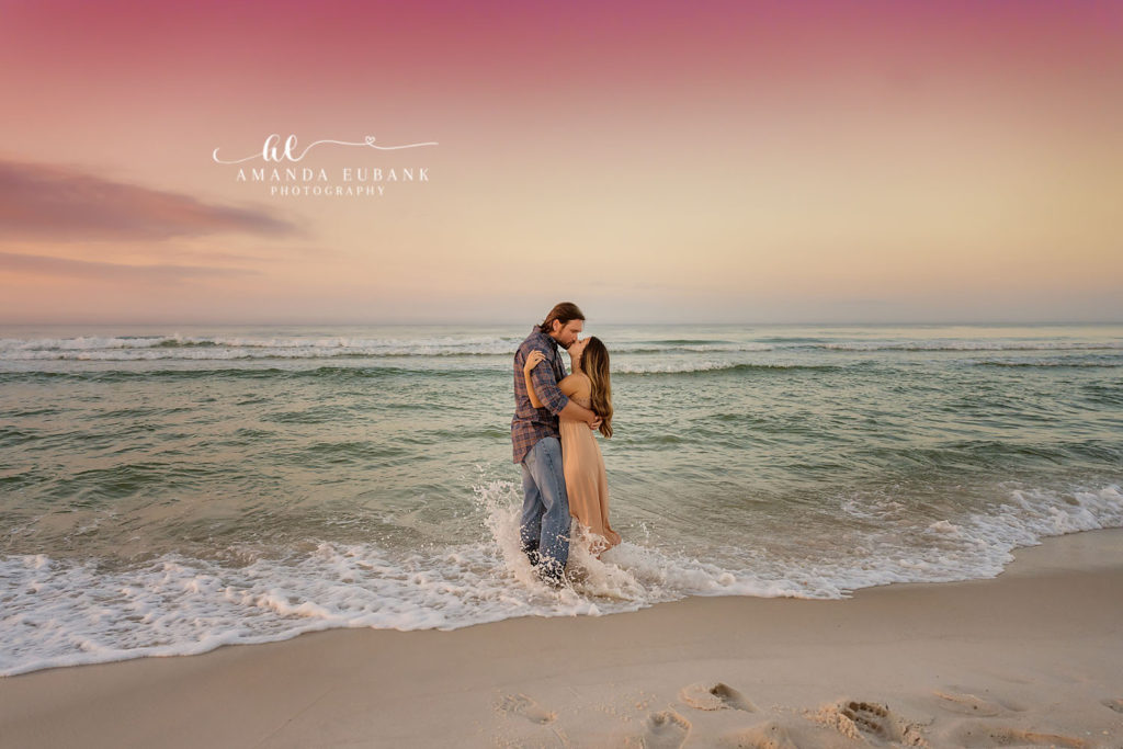 K and B walking the shoreline with waves curling behind them at sunset on 30A.