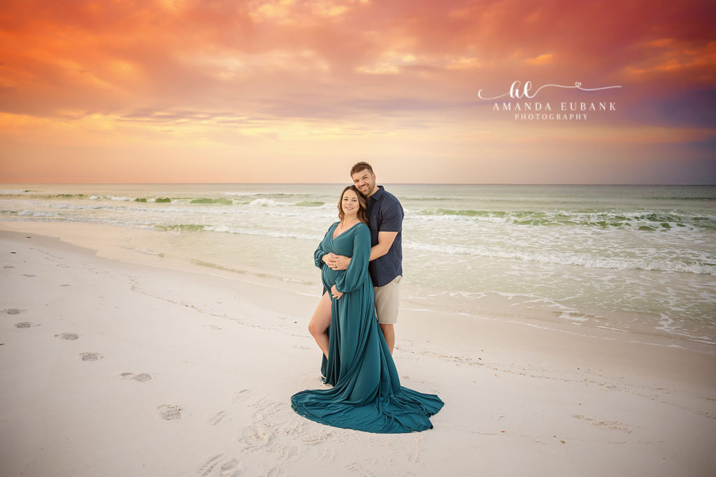 Shawna and her husband standing close together with their daughter on 30A.