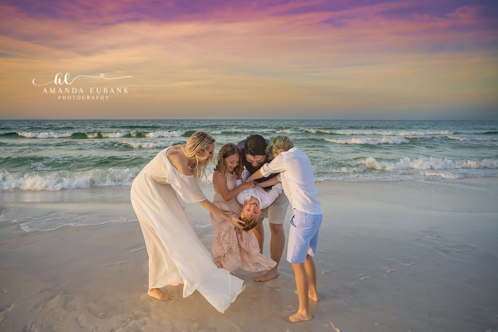 Candid portrait of the Sexton family laughing together on the sand at Dune Allen Beach.