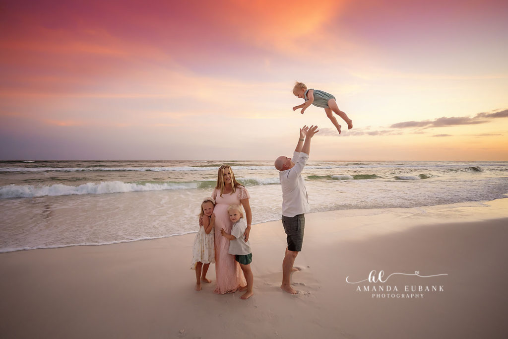 Gulf-warmed maternity family of five — tender father-daughter moment during a candle-warm afterglow on 30A, photographed by a 30A family photographer.