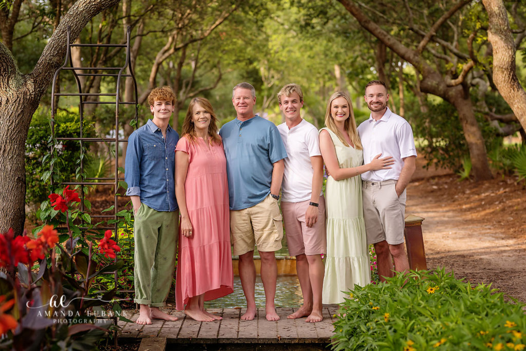 Three brothers from the Fuller family smiling on a bridge in the Watercolor Gardens.