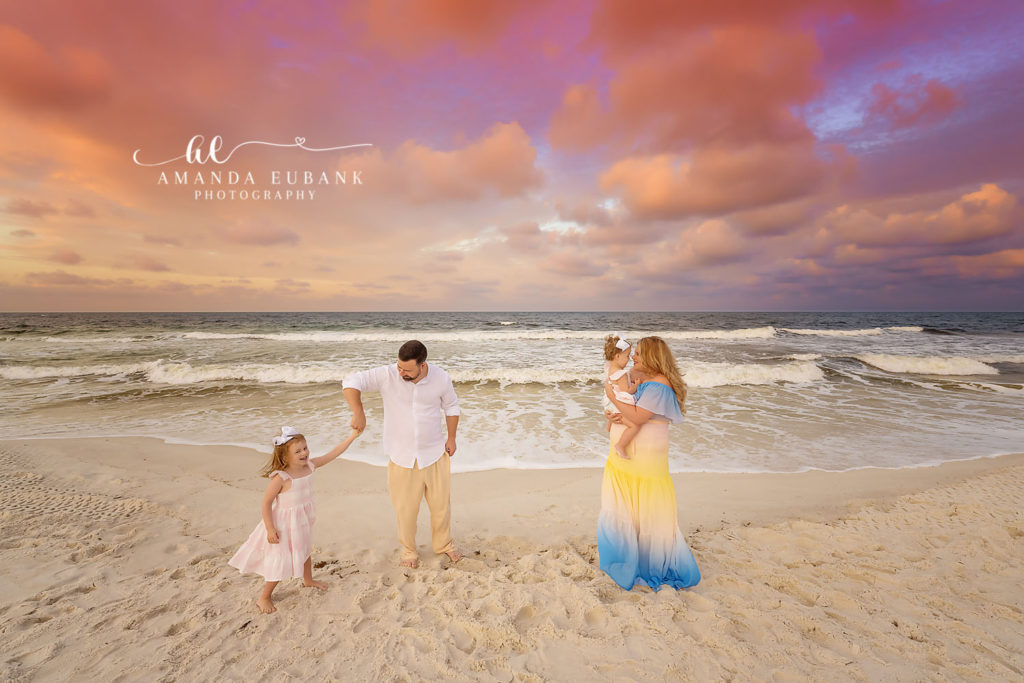 Mom in a flowing ombré chiffon dress with her daughters in pale pink at Carillon Beach.