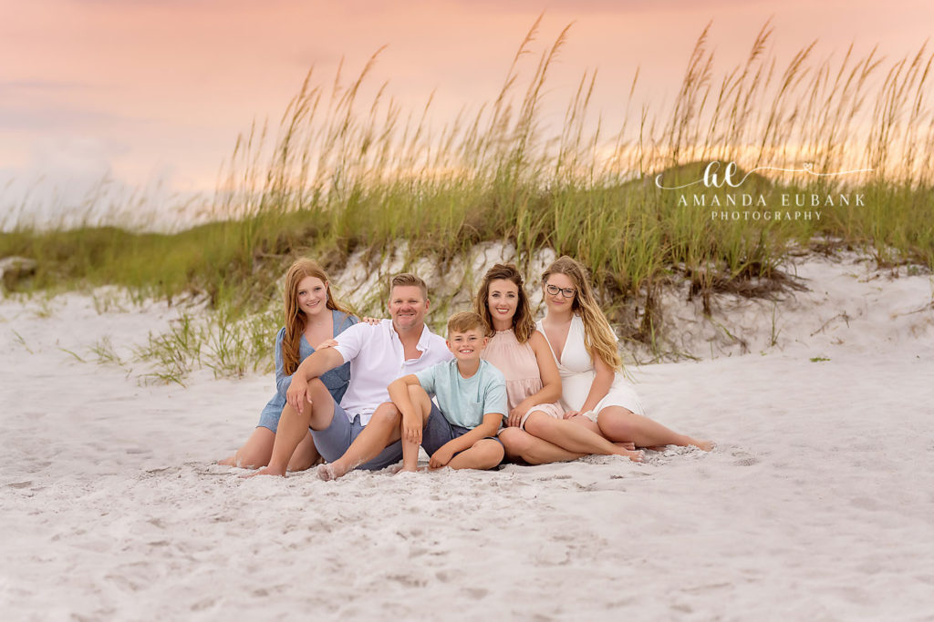Hayden family walking together along the shoreline at Watercolor Beach in coordinated coastal outfits.
