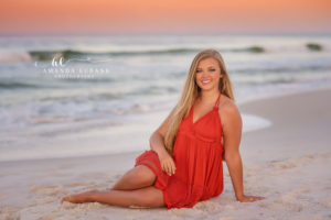 Emily playing in the water in a flowing red halter sundress at Rosemary Beach.