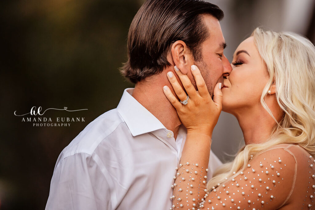 Engaged couple B + S sharing a quiet kiss on the boardwalk in Rosemary Beach at sunset