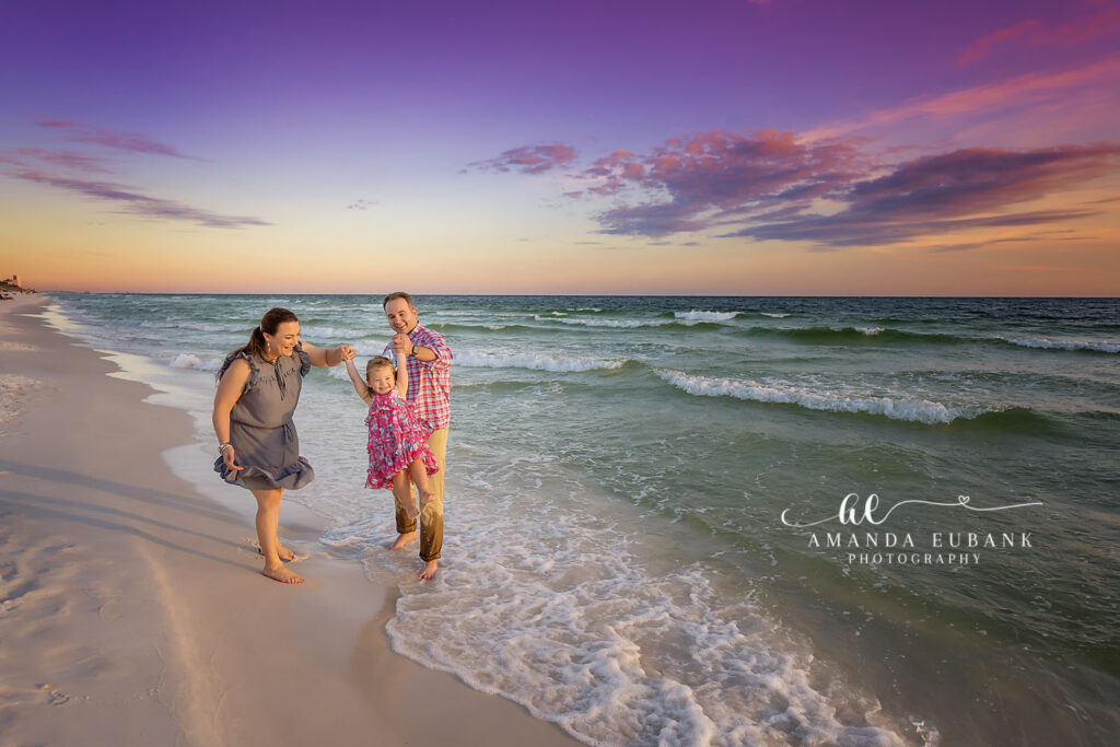 Z mom and toddler splashing along the surf line at Watercolor beach on 30A