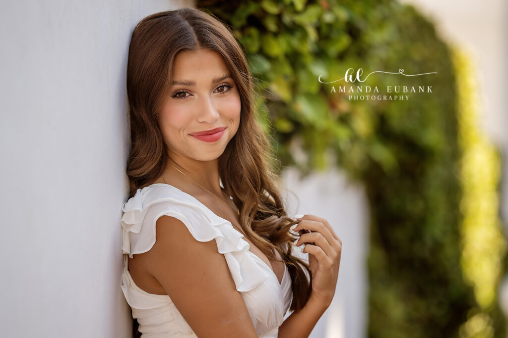 Miss Jade reflecting at a white-stucco column during her Rosemary Beach senior session.