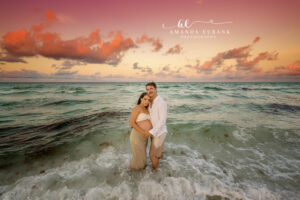 A flowing maternity dress portrait at sunset with sea oats and dunes nearby during rosy horizon glow.