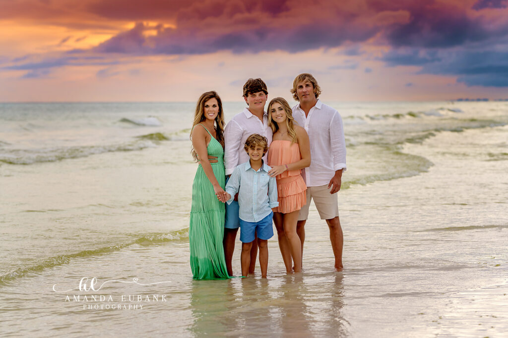 A sweet pose between siblings on a quiet stretch of 30A beach during glowing twilight.