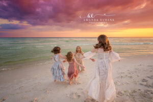 A romantic couple portrait against a sunset sky where the ocean meets the shore during dreamy diffused light.