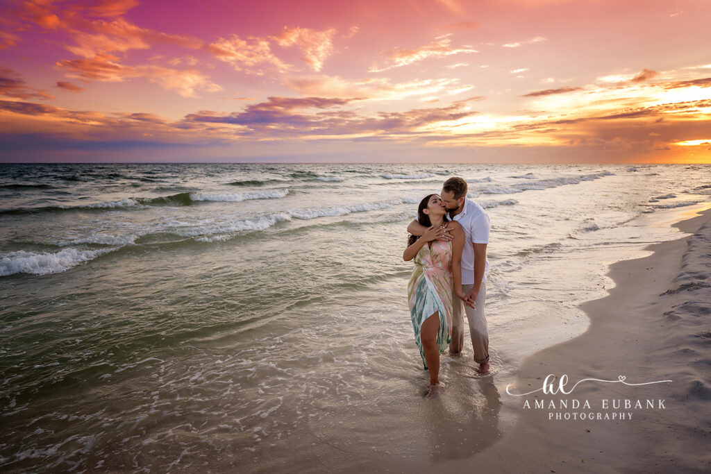Sweet embrace at the surf line as a wave rolls in behind the couple