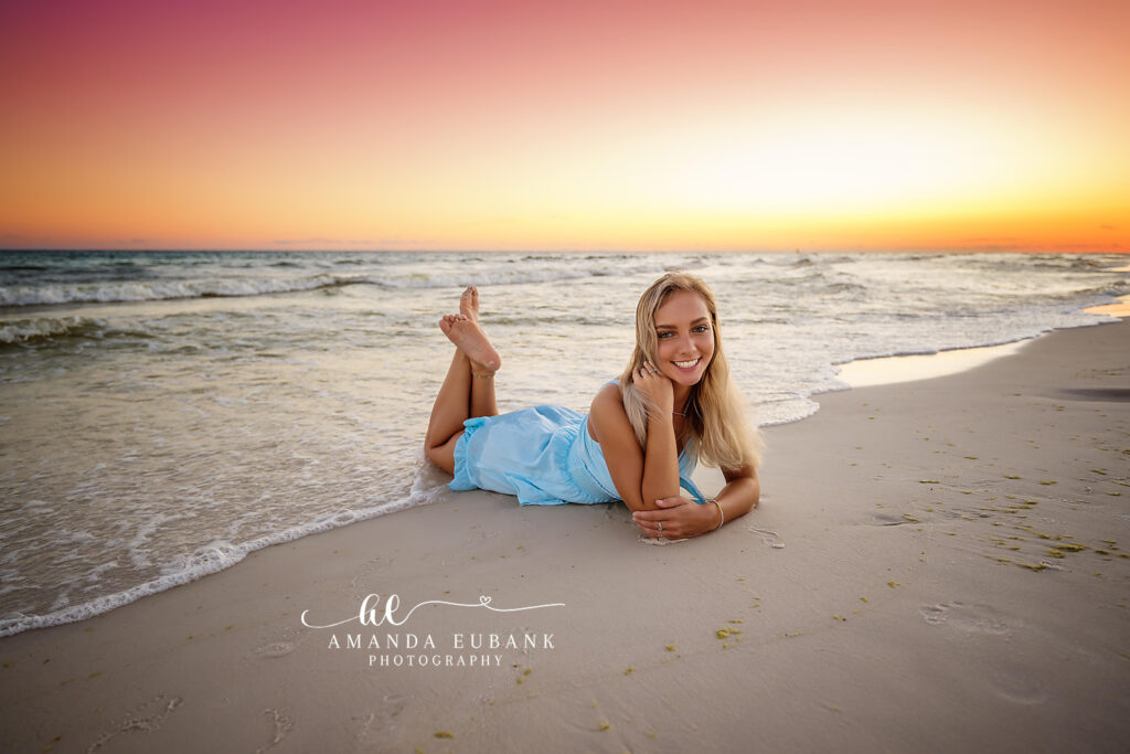 Sunset profile portrait of senior Chloe in a blue spaghetti-strap dress along the Emerald Coast shoreline