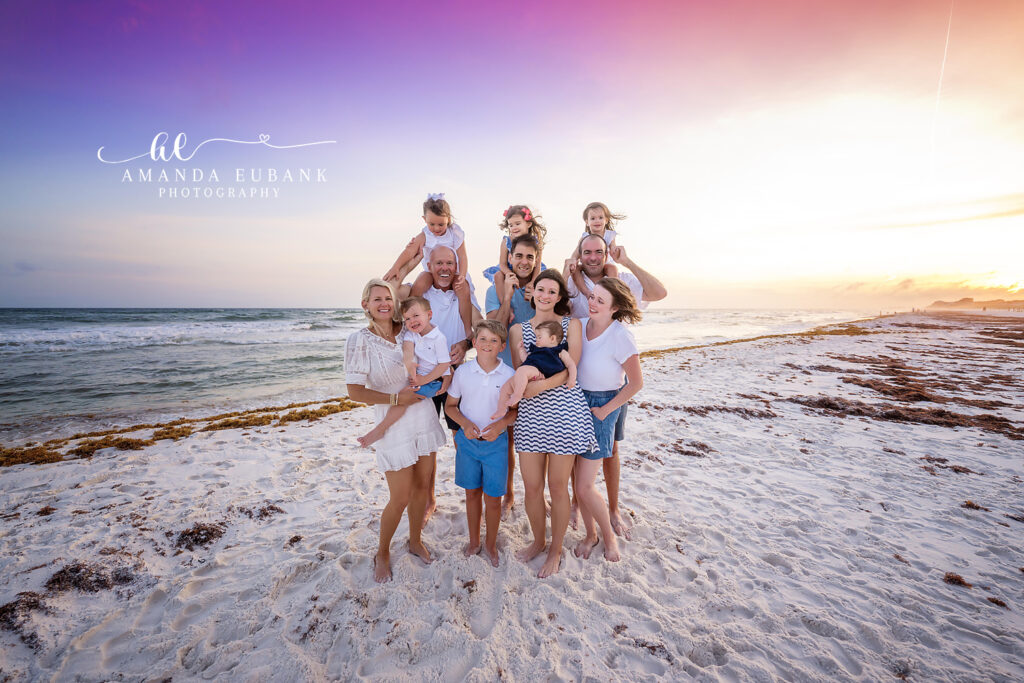 Multi-generational extended L family gathered on the Santa Rosa Beach shoreline at sunset