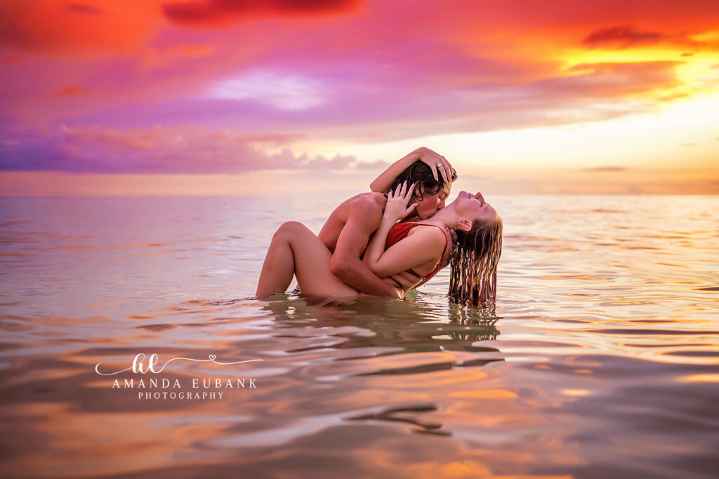 Romantic couples water portrait - tender hold in the water at sunset