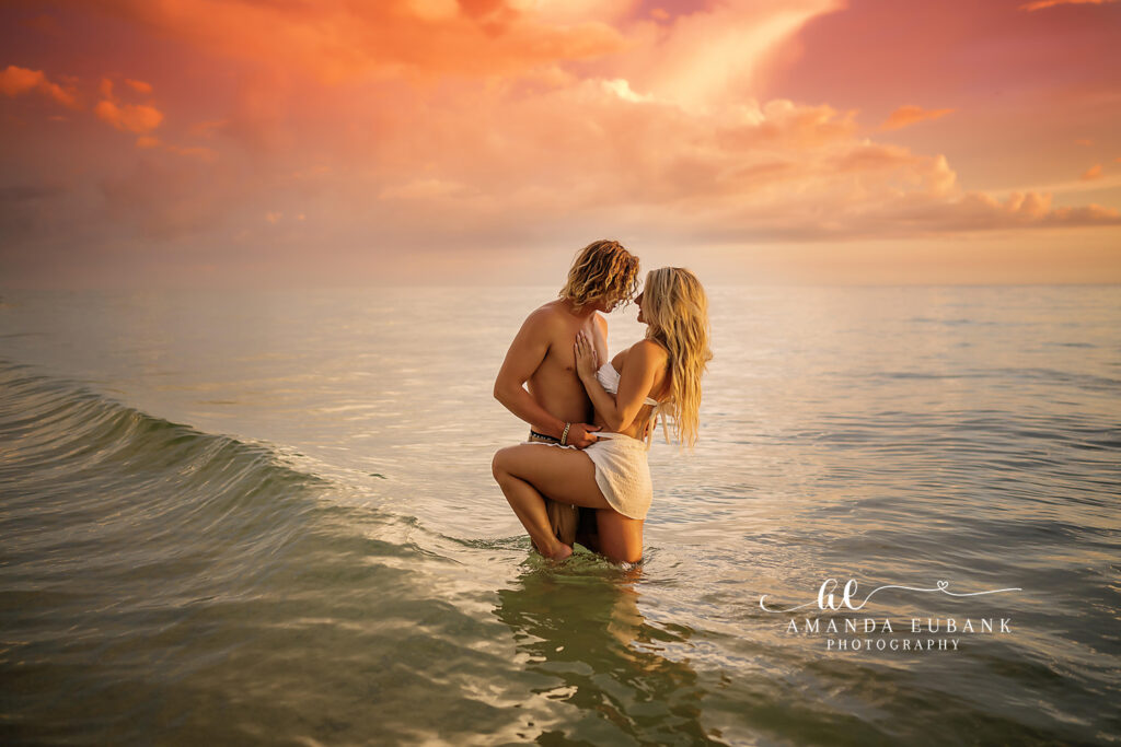 Tender beach embrace between A and M as her champagne sequined gown catches the last warm sunset light along 30A.