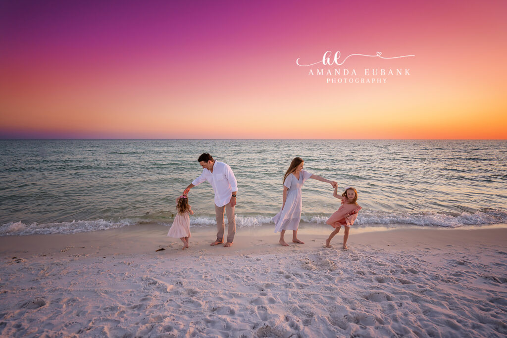 Whole family hugging close as the sun sets behind them on 30A
