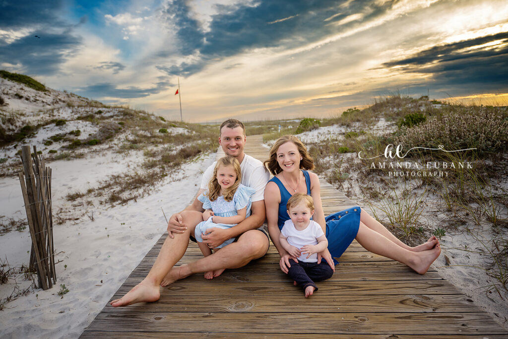 Watersound family beach photographer: grandfather and granddaughter framed by the wooden dune crossover with sea oats glowing in the warm sunset | Watersound FL Family Beach Photographer