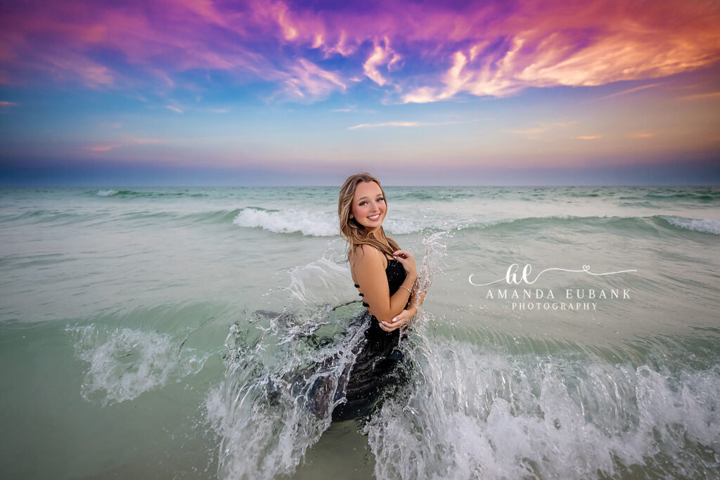 Miss P seated in the soft Santa Rosa Beach sand for a relaxed senior portrait at sunset