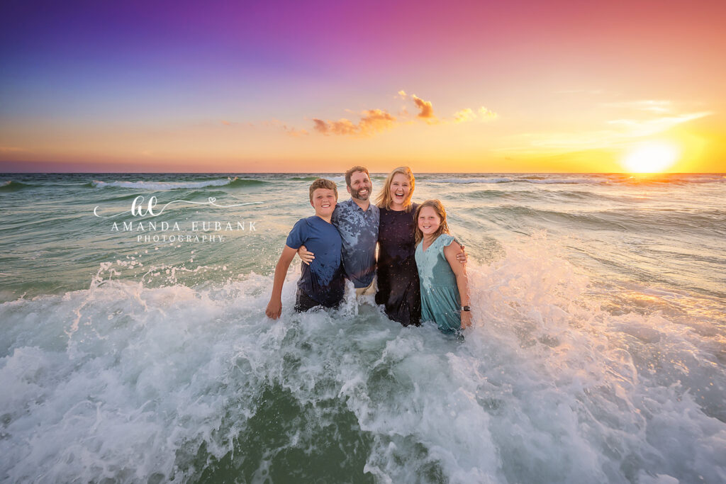 Parents holding their kids in the shallow surf at sunset, 30A fall family beach session