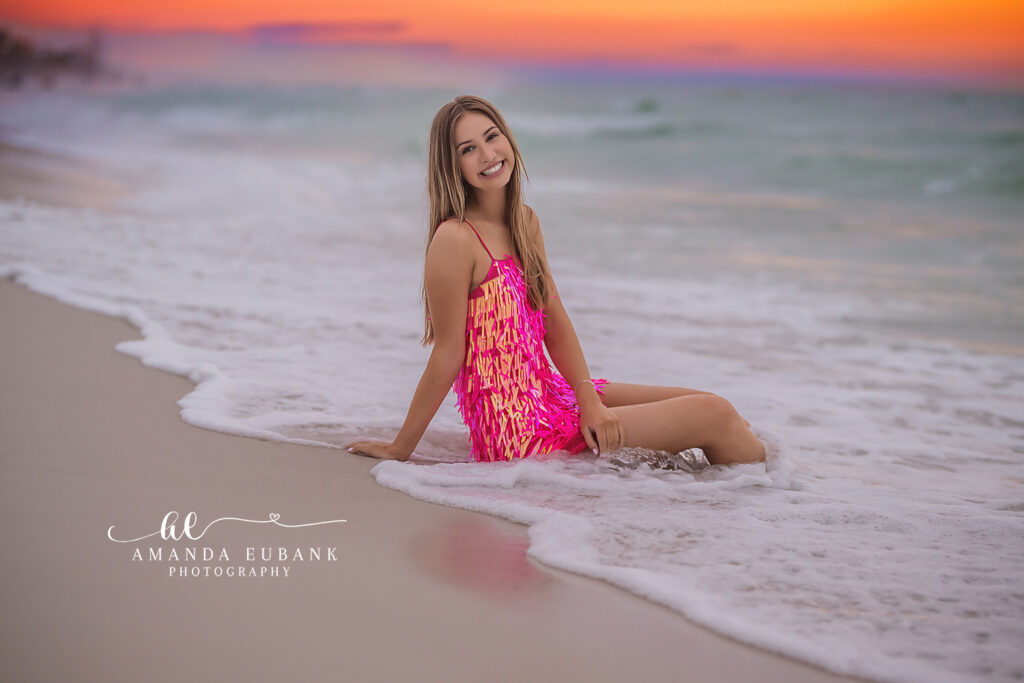 Miss Ivy leaning toward the sunset shoreline in a pink sparkle dress, Watercolor senior session on 30A