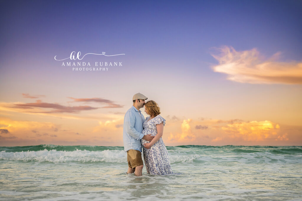 Smith maternity couple stand together on the Destin sand at sunrise.