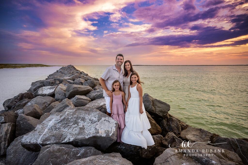 Family laughing at the East Pass jetties during a sunset session in Destin, FL.