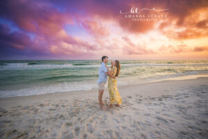 Carillon Beach photographer captures a playful moment as the fiancee lifts her ring hand toward her smiling fiance.