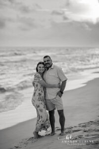Black and white Carillon Beach father-daughter portrait, dad in linen and daughter in flowing floral maxi at sunset.