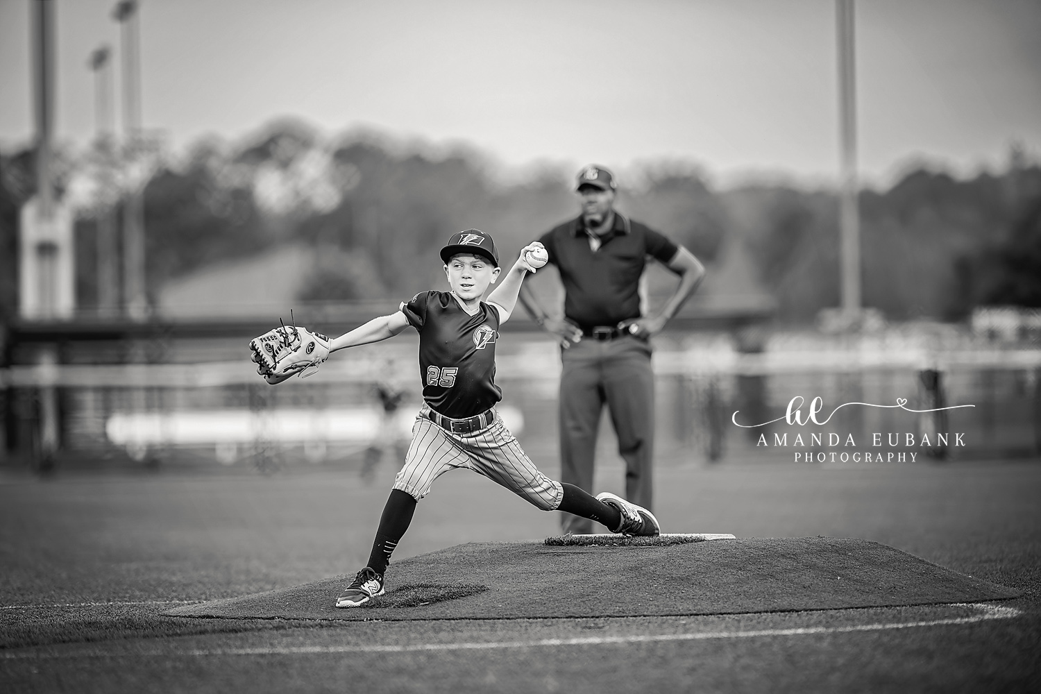 Pitcher Loaded Wind-Up Number 25 | Hoover AL Travel Baseball Photographer Black and white profile shot of a Power 11U Kilcrease pitcher in jersey number 25 reaching peak load on the mound while a coach watches from behind during a Hoover, Alabama tournament game.