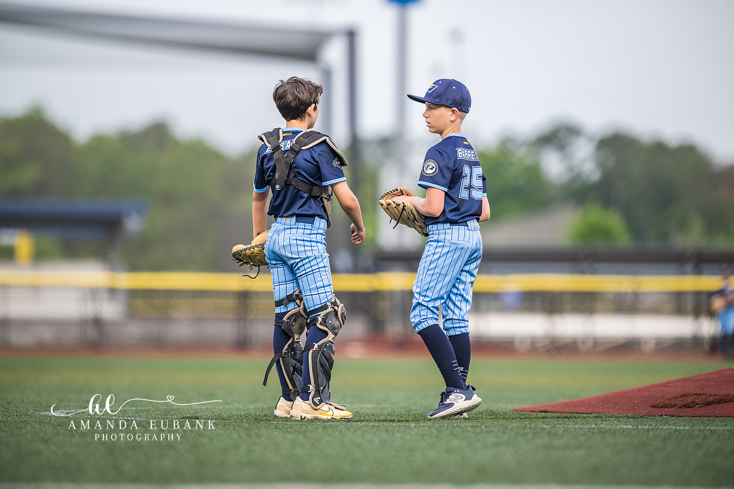 Catcher and Pitcher Mound Visit | Hoover AL Travel Baseball Photographer Power Kilcrease 11U catcher in full gear and teammate Burrell number 25 stand together near the mound during a Hoover, Alabama tournament game.